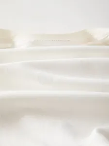 Close-up of soft breathable white knitted cotton fabric for baby rompers and clothing