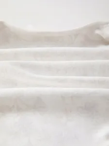 Close-up of soft breathable cotton fabric with elegant floral print for baby jumpsuits