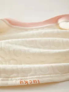 Detailed macro view of quilted soft cotton fabric with lucky print for baby clothing