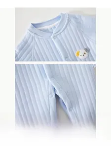 Close-up of resin snaps and cute dog embroidery on light blue quilted baby romper