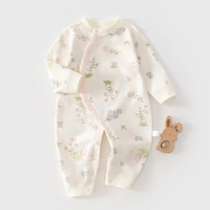 Détail d'une barboteuse en coton pour nouveau-né avec motifs floraux, lapins et boutons-pression