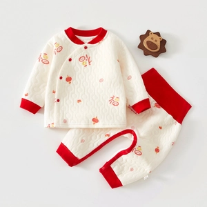 Detail of quilted cotton baby pajamas with festive red lantern and Fu character prints