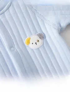 Detail of light blue baby romper with ribbed cotton texture and a 3D dog patch embroidery