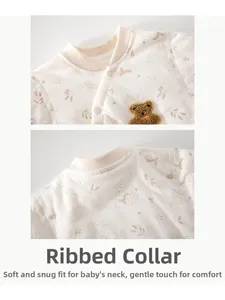 Détail du body en coton pour bébé avec encolure bordée et écusson ours en peluche 3D