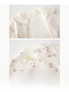 Détail d'un body bébé en coton avec encolure bordée et motif de lapin fleuri