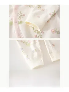 Détail de grenouillère bébé en coton avec imprimé lapin et poignets élastiques côtelés