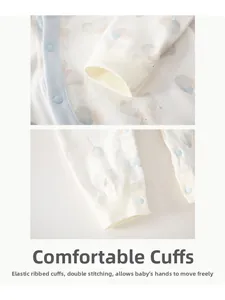 Detail of baby romper ribbed cuffs and bear print with blue snap button closure