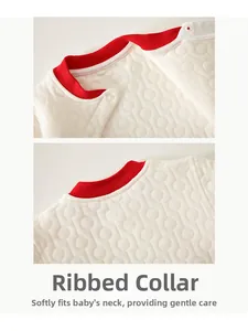 Close-up of quilted baby winter wear with shoulder snaps and soft red edged neckline
