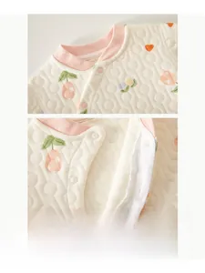 Detail of durable resin snap buttons on quilted cotton thermal baby wear with luck print