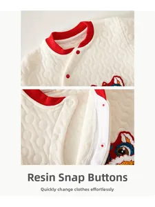 Close-up of quilted baby suit with traditional Chinese lion embroidery and resin buttons