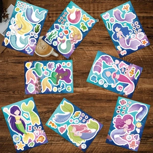 Flat lay of DIY mermaid stickers with diverse accessories on a dark wooden desk