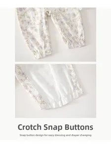 Detail view of floral baby romper featuring snap button crotch and elastic leg cuffs