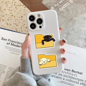 Detail view of a white iPhone case featuring cute dog and lamb folder cartoon stickers