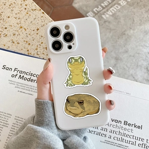 Close-up of white iPhone case featuring creative gecko and frog reptile stickers