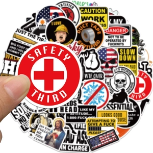 Close-up of waterproof safety stickers for helmets and luggage featuring bold warning labels