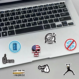 Close-up of assorted waterproof vinyl stickers on a laptop surface showing diverse designs