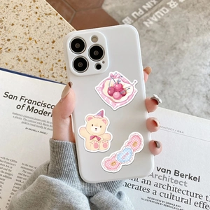 White phone case with cute pink cherry, bear and love heart stickers in hand