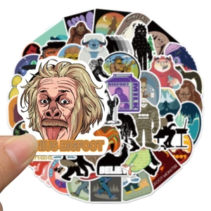 Close-up of a cartoon Bigfoot sticker with genius theme held by hand for decoration