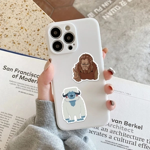 Close-up of white iPhone case featuring cartoon ape stickers in a lifestyle setting