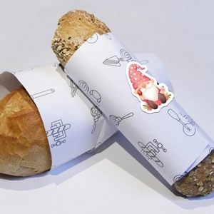 Detail of cute gnome sticker on white bread packaging paper with baking tool icons