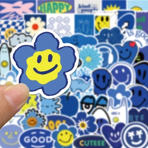 Close-up of blue and yellow cartoon smiley face flower stickers for laptop and skateboards
