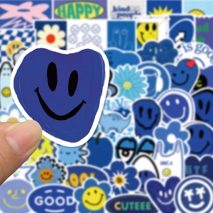 Detailed macro view of Klein blue graffiti stickers with happy face and floral patterns