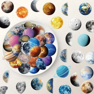 Close-up of waterproof solar system stickers featuring planets and moon phases on marble surface