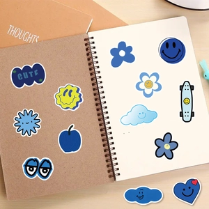 Macro shot of blue smiley face stickers on a spiral notebook with cute flower patterns