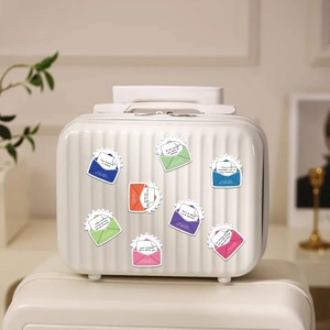 Colorful motivational envelope stickers displayed as decoration on a white suitcase