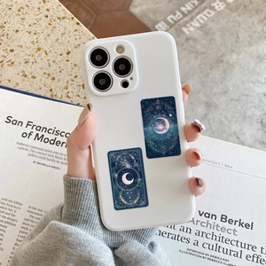 Detailed view of gothic tarot moon stickers applied on a sleek white smartphone case