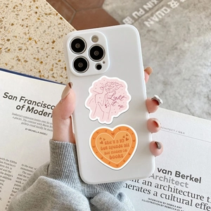 Close-up of romantic bookish stickers with text applied on a white smartphone case