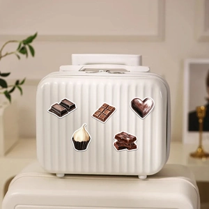 Adesivi a tema cioccolato su mini valigia bianca per idee creative di decorazione fai-da-te
