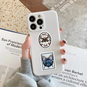 Detail of gothic moth and blue rose stamp stickers on a minimalist white phone case