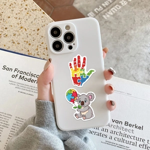 Detalle de pegatinas coloridas de concienciación sobre el autismo en una funda blanca