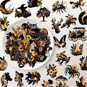 Detailed view of floral stickers with dark nature themes like owls and magic on white plate