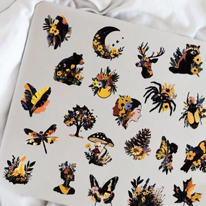 Close-up of decorative floral and wildlife PET stickers applied on a laptop lid
