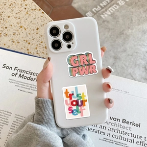 Coque iPhone blanche avec lettrage coloré GRL PWR et trust your self dans une main