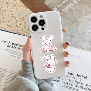 Close-up of white phone case with cute pink cartoon bunnies on marble background