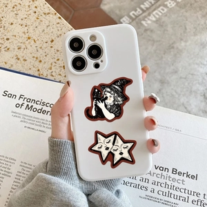 Hand holding iPhone case with celestial witch and black cat vintage art stickers