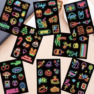 Neon style decorative waterproof stickers for laptops and water bottles on a wooden desk