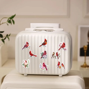 Macro shot of realistic red cardinal stickers with floral motifs on a white vanity case
