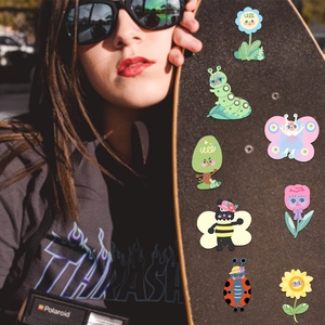 Close-up of 8 colorful cartoon garden animal stickers decorated on a cool street skateboard