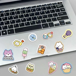 Detailed view of cute cartoon animal stickers applied on a silver laptop and desk surface