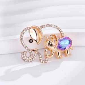 Élégante broche éléphant dorée avec cristal violet et strass sur des marches blanches