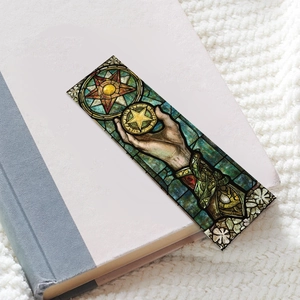 Macro shot of tarot style stained glass bookmark resting on a textured book page