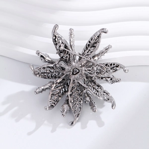 Vintage silver hollow flower brooch with rhinestones on a white textured background