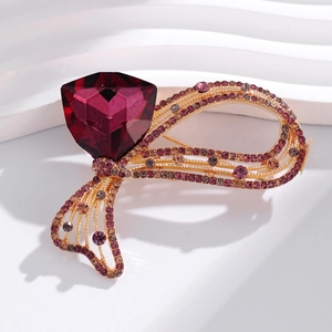 Gros plan d'une broche nœud de luxe avec une grande pierre magenta et des cristaux