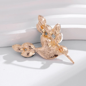 Vue arrière d'une broche colibri en métal doré pâle avec texture de plumes détaillée