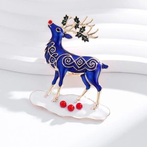 Detail of royal blue enamel reindeer brooch with golden antlers and festive red bead accents