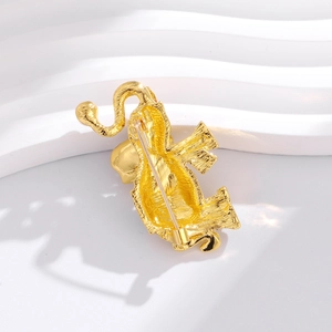 Elegant gold-plated elephant brooch with matte texture and safety pin on white stand